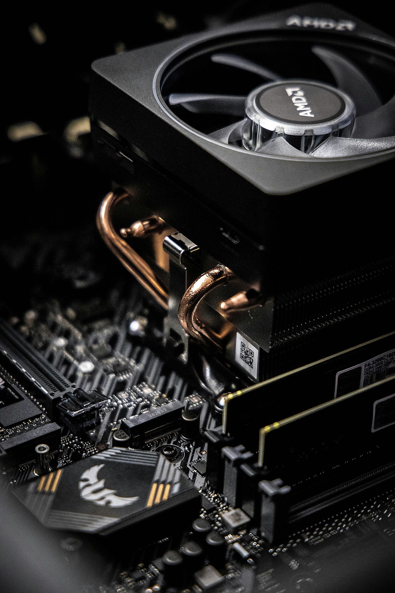 Nahaufnahme eines Mainboards mit CPU-Kühler, Kupfer-Heatpipes und Arbeitsspeicher.